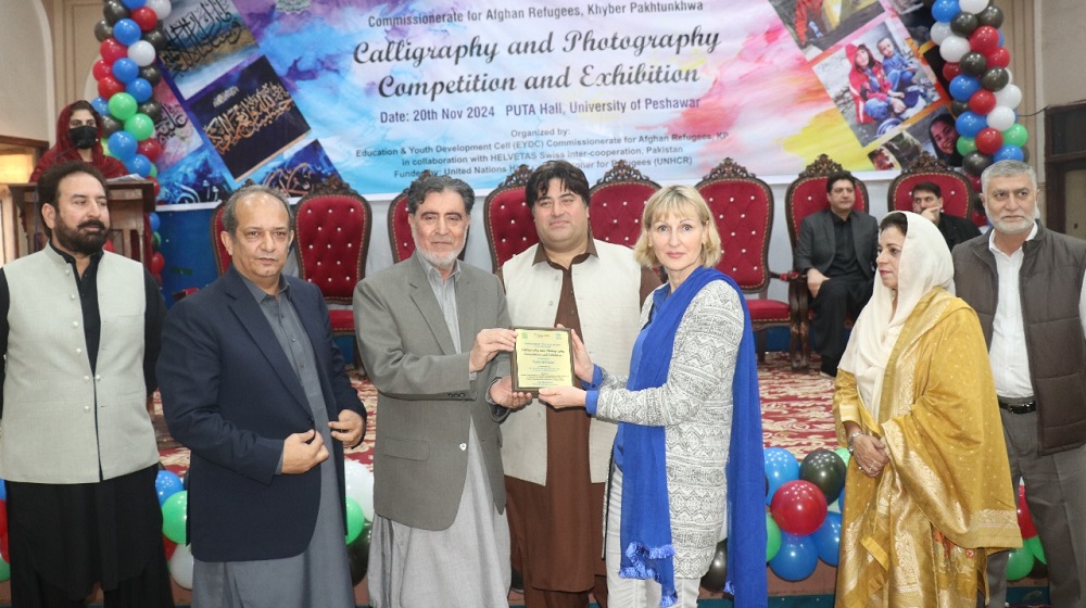 Ms. Heidi Hermann, Project Director SSARC from German Technical Cooperation, GIZ is receiving a Shield at the eve of Painting and Calligraphy exhibition sketching Afghan Refugees lives under the auspices of Afghan Commissionerate.