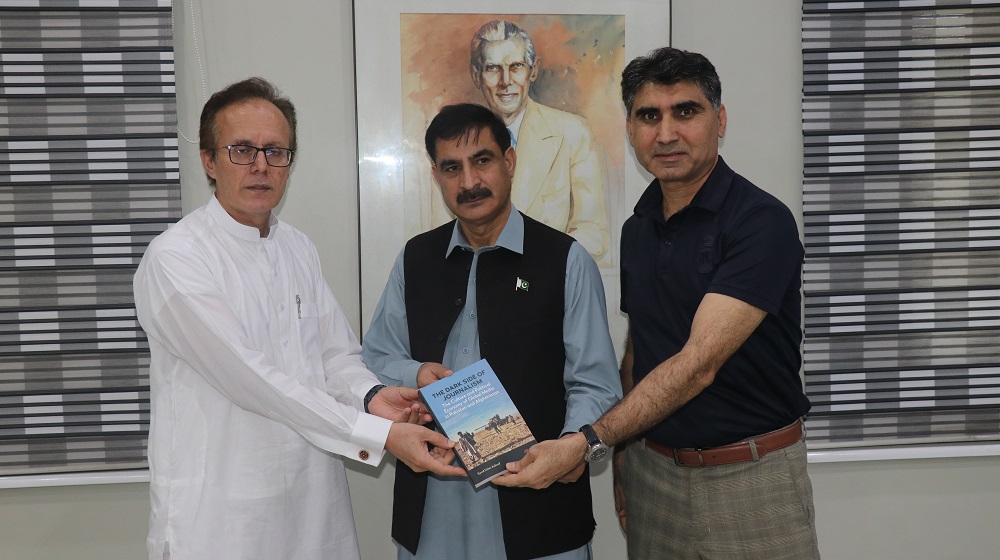 Dr. Syed Irfan Ashraf (Right) while accompanied by Prof. Dr. Faizullah Jan (Left) presents his book 